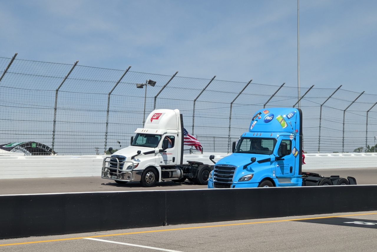 Truck cabs drive around a track