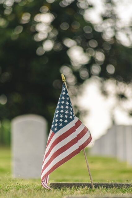 An American flag stands in a cemetery