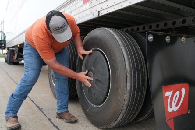 A man adjusts a tire on a truck