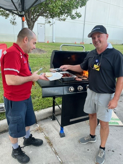 Operations Manager Luke Lenius (right) mans the grill.