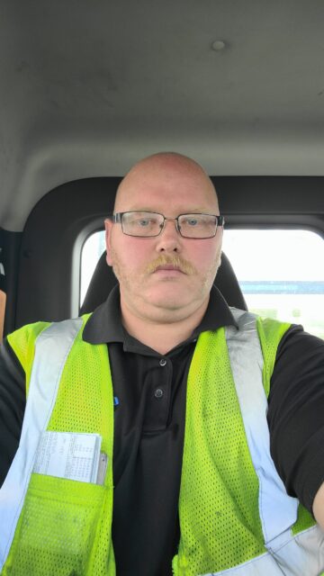 Ryan Baker sits in the cab of a truck.