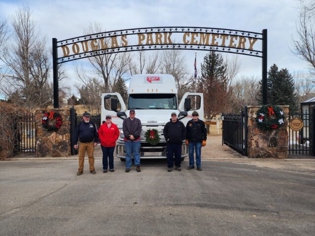 A group of people stands in front of Douglas Park Cemetery