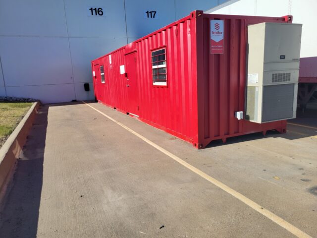 A red shed in a parking lot