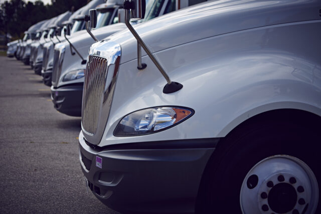 A row of semi-trucks in a parking lot