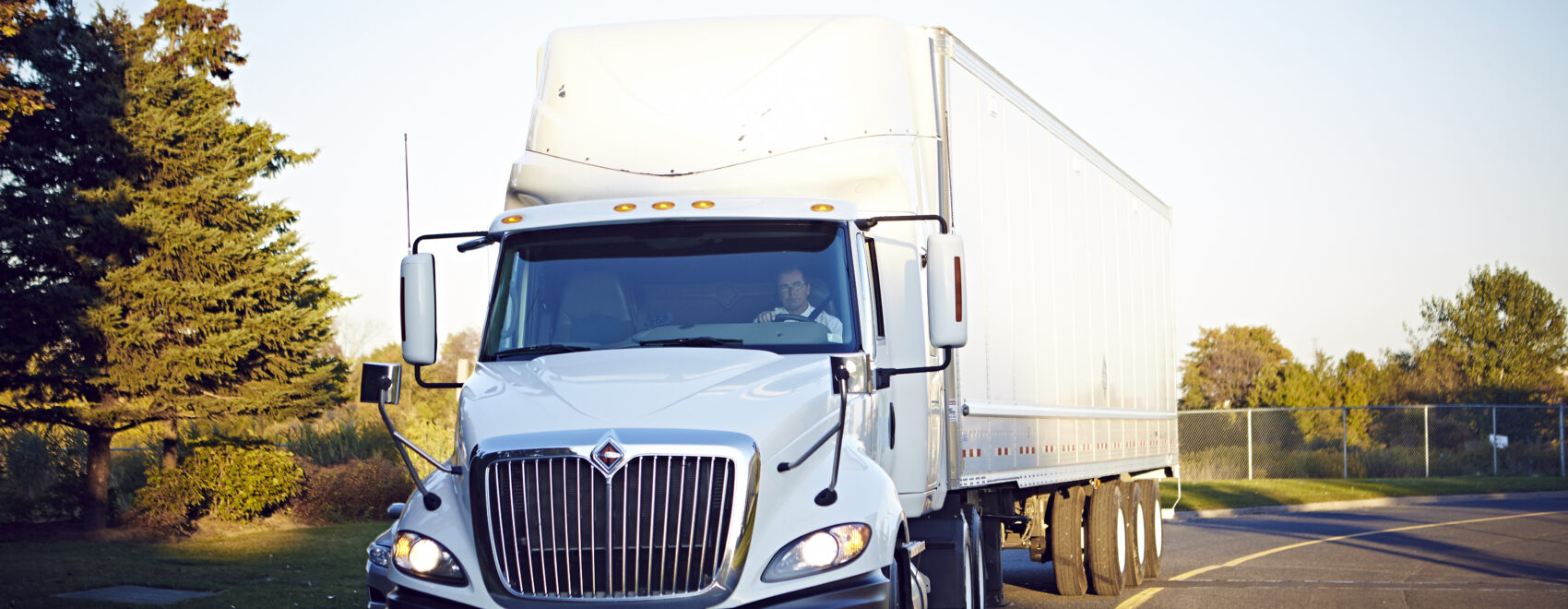 A semi-truck drives down a curved road.