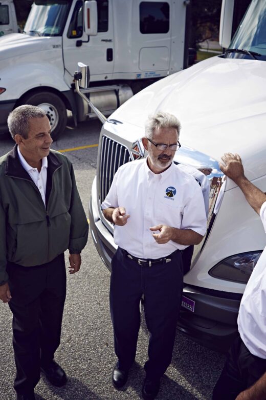 Pictured: Drivers in front of trucks